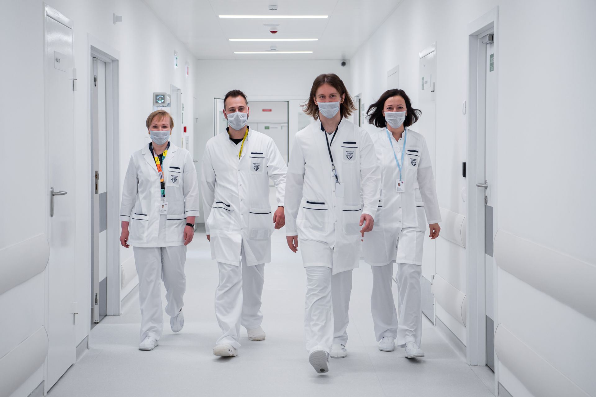 Medical team in white coats walking through a bright hospital corridor